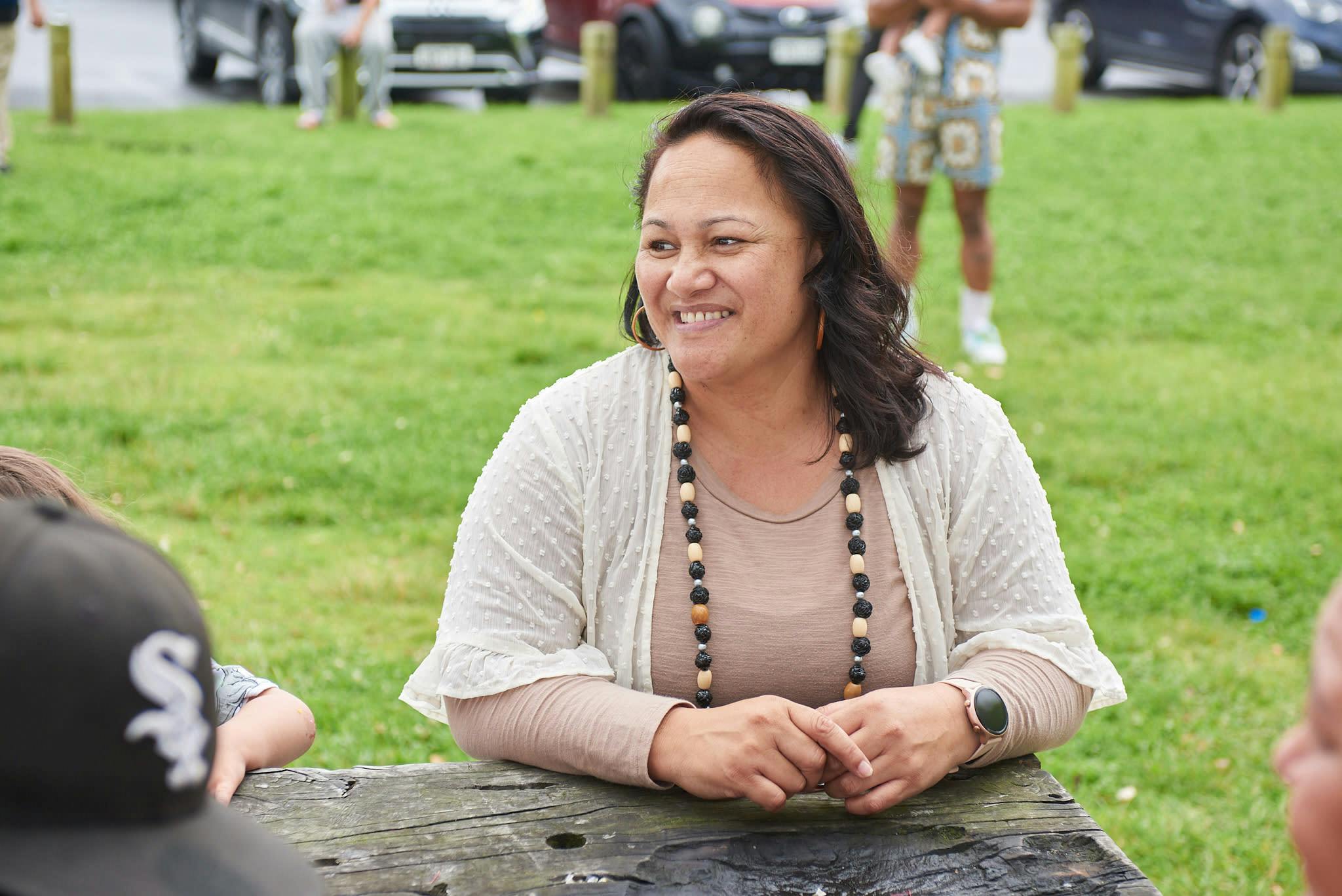 Māori woman sitting at picnic bench